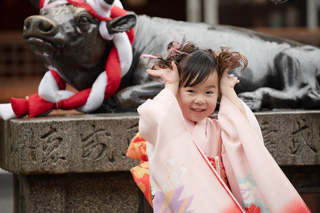 七五三の出張撮影|牛の銅像をバックに牛のポーズがとっても可愛いいです。
